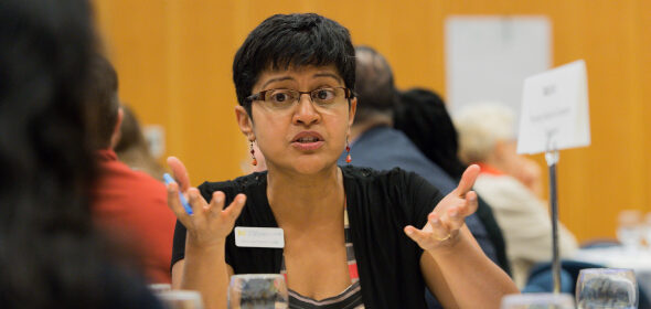 A woman speaks to her table during a group workshop event