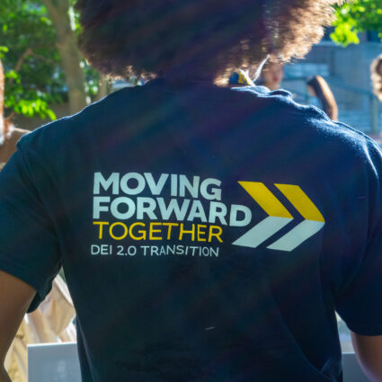 Students attending Festifall on the Diag. The back of a student's t-shirt says Moving Forward Together: DEI 2.0 Transition