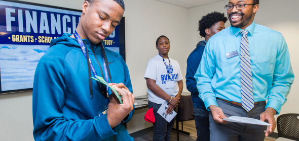 A young person engages in an activity about financial aid with an advisor