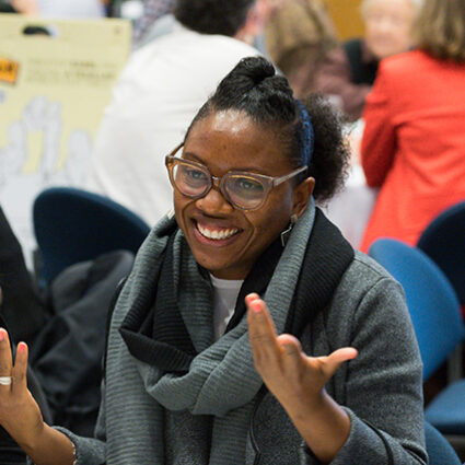 A faculty member smiling and gesturing at the Faculty Community Conversation