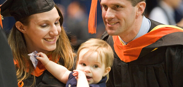 Two Engineering students graduating with their baby between them